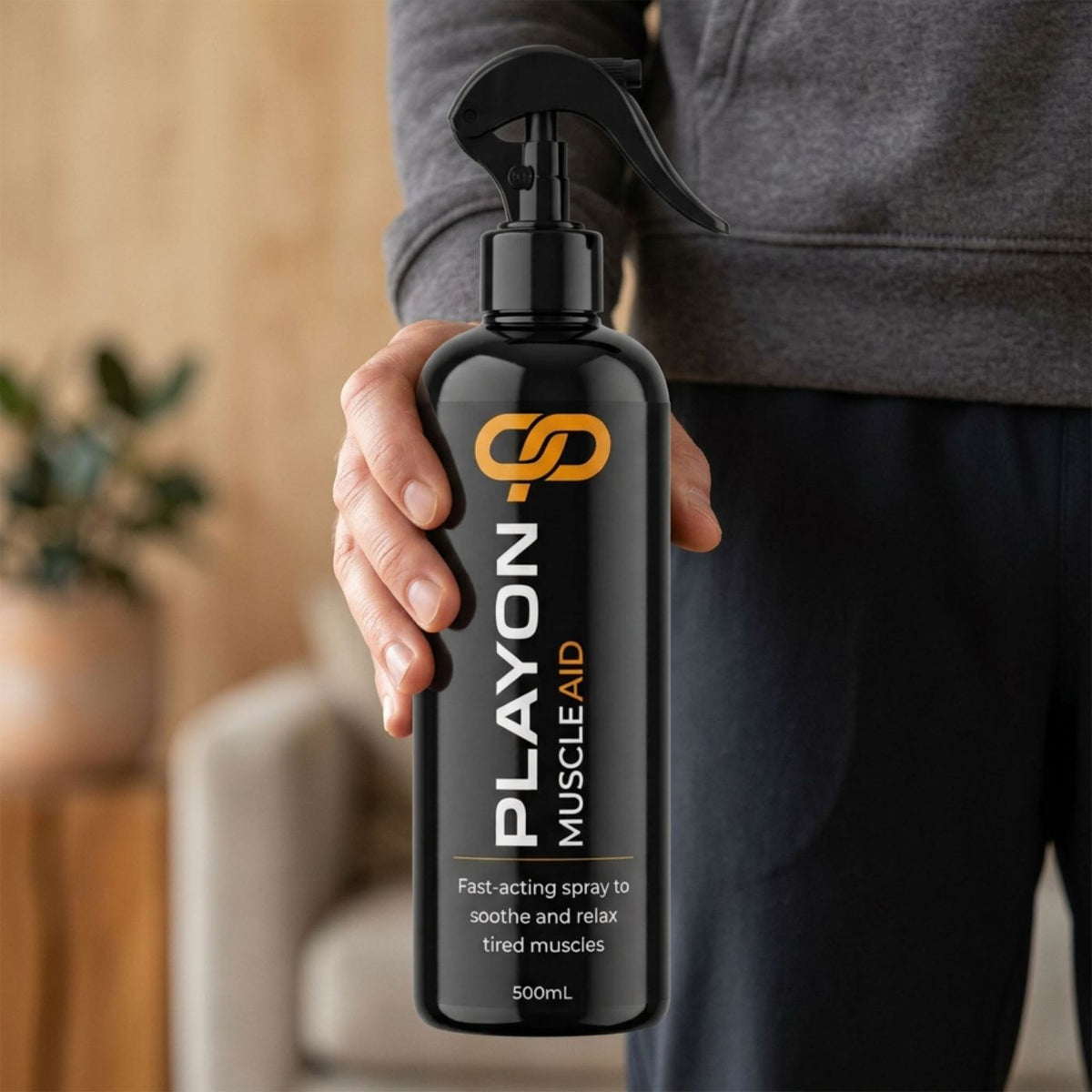 Adult holding a PLAYON Muscle Aid 500ml trigger spray bottle