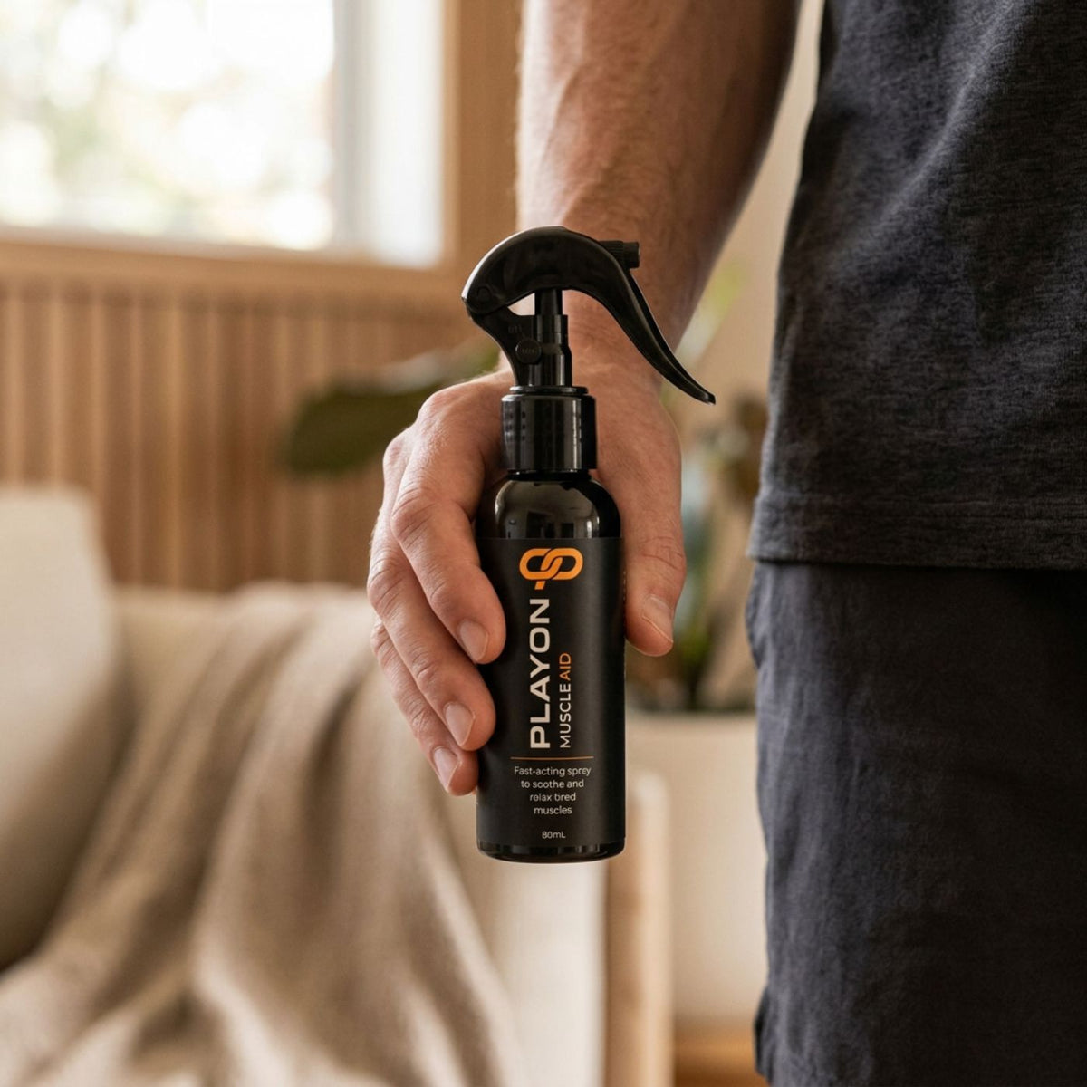 Adult holding a PLAYON Muscle Aid 80ml trigger spray bottle